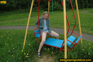 Hot young chick in public playground raise skirt and slide panty to piss on swing - Picture 14