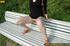 Cute naughty chick on a stroll stops to bend on park bench and spray piss