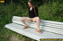 Cute naughty chick on a stroll stops to bend on park bench and spray piss