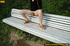 Cute naughty chick on a stroll stops to bend on park bench and spray piss