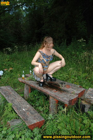 Long hair babe looking sweet climbs an old table in forest to spray hot piss - Picture 6