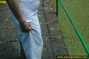 Seductive looking babe on a stroll raises clothes to pee out in the park - Picture 3