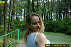 Seductive looking babe on a stroll raises clothes to pee out in the park - Picture 4