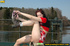 Naughty smiling young chick in red sits down and spreads legs to spray