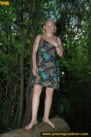 Horny blonde in cute short skirt takes walk in woods and pisses on tree trunk - Picture 1