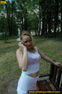 Young pretty blonde in glasses and short skirt sits on public bench to