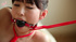 Pretty young Asian babe in red restraints gets tickled and pleasured erotically