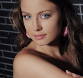 Curled hair girl adores to touch her body with pink feathers