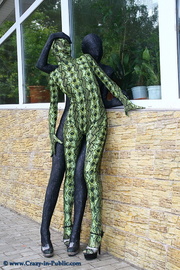 Two flexible green and black zentai wearing chick exposing themselves outdoor.