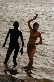 Two hot black and baige zentai wearing teen enjoying themselves on the beach.