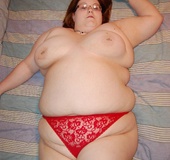 Busty BBW mom in tight red panties teasing in her bedroom.