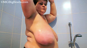 Short-haired fatty swinging her giant tits while showering