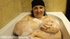 Big-titted old bitch in a black hat taking bubble bath