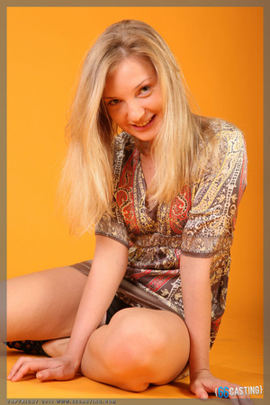 Blonde girl in a red dress with low dicolleti posing for her first casting - Picture 1