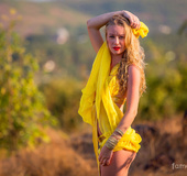 Young enchantress with hot tits looks inviting posing with yellow silk