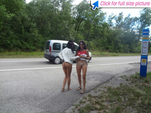 Two slutty moms lift up their skirt at the road to show off their cunts - Picture 1
