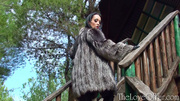 Brunette MILF in lingerie and silver fox coat posing outdoors