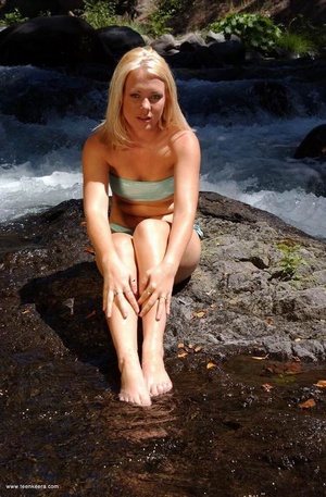 Blonde teen babe takes off her bikini to pose nude a the mountain river - Picture 6
