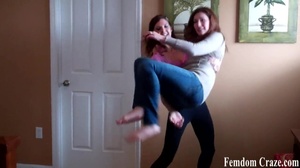 Playful girls in jeans picking up each other to show their strength - Picture 2