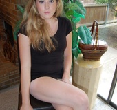 Blonde babe in a black dress shows off her asshole