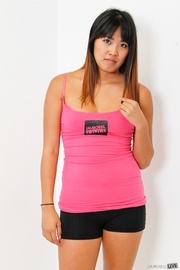 Curvy Asian chick in a pink top and black shorts is waiting for you