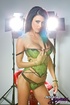 Angelic fox in green lingerie fingers her ass and pussy in the studio.