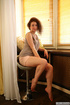 Fun minx in a grey shirt and green panties poses by the window.