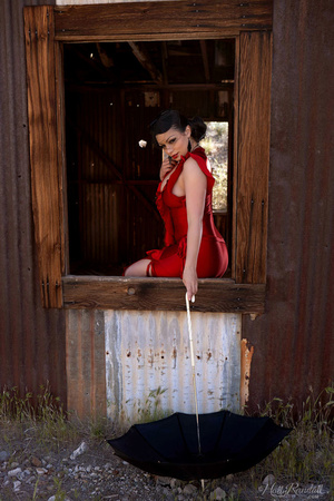 Sexy bimbo in a red dress with slits posing in a secluded old house in the countyside. - Picture 4