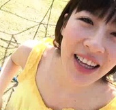Slim Japanese coed in a yellow top on the kids' palyground