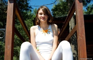 Skinny sweetie in a white top and leggings gets naked outdoors. - Picture 1