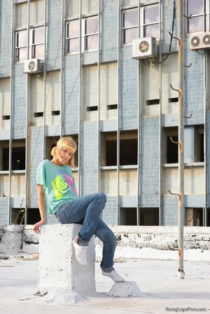 Short-haired blonde in a green printed shirt and jeans gets naked and climbs a pole. - XXXonXXX - Pic 1