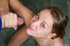 Playful fair-haired teen in green shorts takes selfies before a dirty