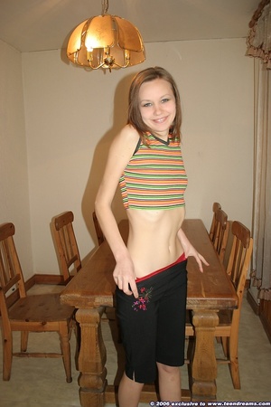 Attractive teen in dining room seductively strips down to stockings to show assets - Picture 4