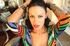 Fascinating damsel in multi colored tight gown uses makeup and admires