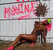 Taunting model in colorful net top and pink heels struts and poses on