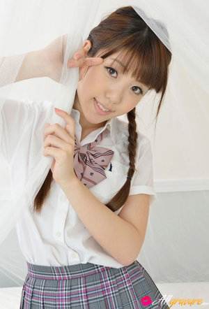 Toots in a plaid skirt and white blouse poses on white sheets. - Picture 9