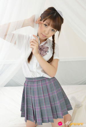 Toots in a plaid skirt and white blouse poses on white sheets. - Picture 10