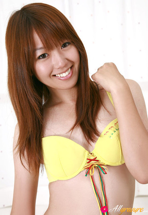 Dish models in her a yellow bikini on white sheets. - Picture 1