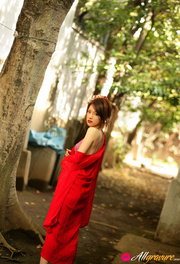Harlot in a red robe and purple bikini poses under a tree.