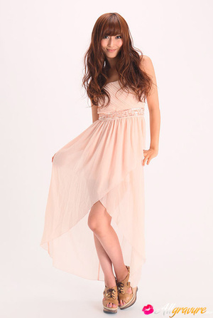 Vamp poses in her pink dress and wedges against a white background. - Picture 1