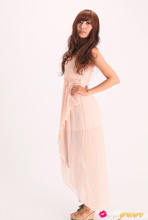 Vamp poses in her pink dress and wedges against a white background. - Picture 2