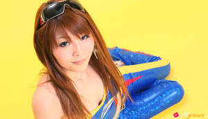 Pit diva in blue leather gear poses against a yellow background. - Picture 8