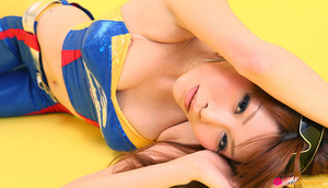 Pit diva in blue leather gear poses against a yellow background. - Picture 14