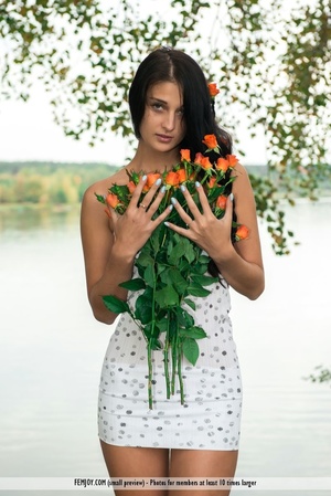 Exotic beauty with black hair in a white dress poses with orange roses. - XXXonXXX - Pic 1
