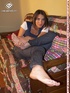 Brunette freshie in a striped T-shirt and jeans takes off her sneakers
