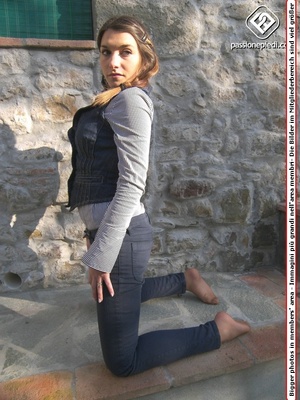 Lovely brunette teen in jeans and vest demonstrating her sexy feet in tights outdoors - Picture 6