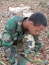 Gentleman in battle dress uniform lays down on fallen leaves to display