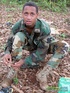 Gentleman in battle dress uniform lays down on fallen leaves to display