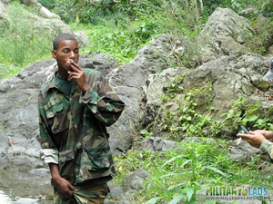 Two men in camo clothes chilling out by the river. - Picture 12
