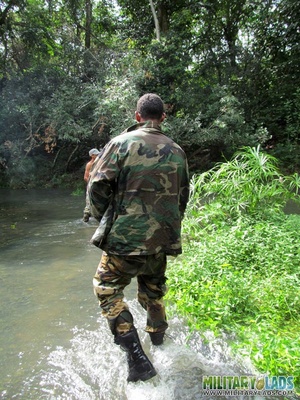 Guy in military uniform gets on his knees in the river to suck cock while jerking off. - Picture 1